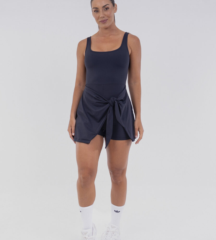 Vestido Macaquinho Preto com short embutido e amarração lateral, ideal para treinos e momentos casuais.